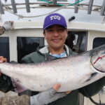 TCU fan catching fish in Alaska